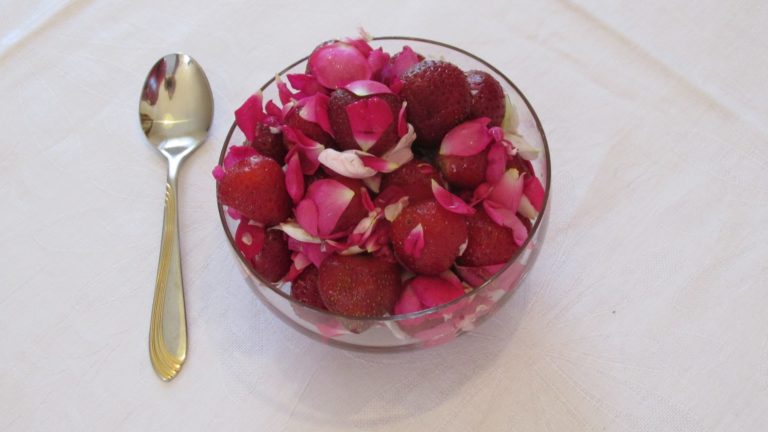 Schale mit Erdbeeren und Rosenblüten